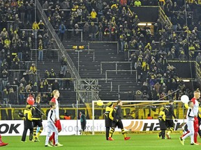 Players enter the pitch in front of empty places on the famous Dortmund South Tribune for the German Bundesliga soccer match between Borussia Dortmund and FC Augsburg in Dortmund, Germany, Monday, Feb 26, 2018. Thousands of supporters protest against Bundesliga matches on Mondays.