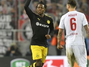 Dortmund's new forward Michy Batshuayi celebrates beside Cologne's Marco Hoeger after scoring the opening goal during the German Bundesliga soccer match between 1. FC Cologne and Borussia Dortmund in Cologne, Germany, Friday, Feb. 2, 2018.