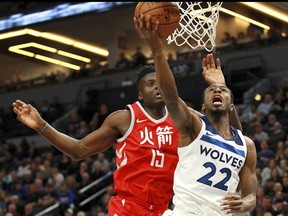 Minnesota Timberwolves forward Andrew Wiggins (22) shoots in front of Houston Rockets' Clint Capela (15) during the first quarter of an NBA basketball game Tuesday, Feb. 13, 2018, in Minneapolis.