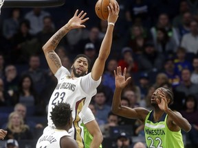 New Orleans Pelicans' Anthony Davis, left, beats Minnesota Timberwolves' Andrew Wiggins to a rebound in the first half of an NBA basketball game Saturday, Feb. 3, 2018, in Minneapolis.