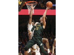 Michigan State's Matt McQuaid, right, shoots as Minnesota's Jordan Murphy defends during the first half of an NCAA college basketball game Tuesday, Feb. 13, 2018, in Minneapolis.