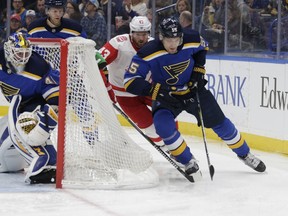 St. Louis Blues' Colton Parayko (55) holds off Detroit Red Wings' Darren Helm (43) as they chase the puck behind the net as goaltender Carter Hutton (40) looks on in the first period of an NHL hockey game, Wednesday, Feb. 28, 2018 in St. Louis.