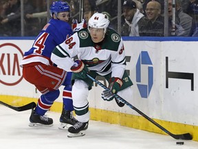 With New York Rangers defenseman Neal Pionk (44) looking on, Minnesota Wild right wing Mikael Granlund (64) looks to pass during the first period of an NHL hockey game in New York, Friday, Feb. 23, 2018.