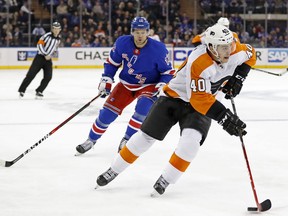 New York Rangers center Peter Holland (12) chases Philadelphia Flyers center Jordan Weal (40) in the first period of an NHL hockey game in New York, Sunday, Feb. 18, 2018.