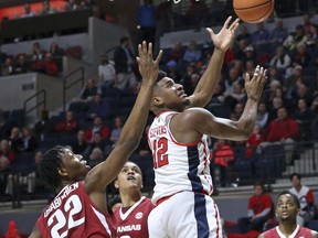 Mississippi forward Bruce Stevens (12) drives to the basket as Arkansas forward Gabe Osabuohien (22) defends during an NCAA college basketball game in Oxford, Miss., Tuesday, Feb. 13, 2018.