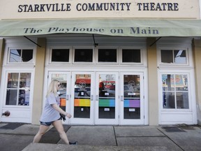 A resident walks past the Starkville Community Theatre in downtown Starkville, Miss., Thursday, Feb. 22, 2018. The doors are decorated with colored panels representing the LGBTQ rainbow flag, done in support to an effort mount the Mississippi college town's first-ever gay pride parade. Starkville aldermen voted 4-3 Tuesday to deny the parade permit requested by Starkville Pride, an LGBT support group.