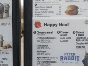 A portion of a drive thru menu panel featuring Happy Meals is seen at a McDonald's Restaurant in Ridgeland, Miss., on Wednesday, Feb. 14, 2018. The company will soon banish cheeseburgers and chocolate milk from its Happy Meal menu in an effort to cut down on the calories, sodium, saturated fat and sugar that kids consume at its restaurants. Diners can still ask specifically for cheeseburgers or chocolate milk with the kid's meal, but the fast-food company said that not listing them will reduce how often they're ordered.