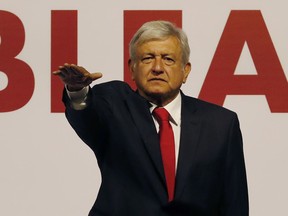 Andres Manuel Lopez Obrador holds his hand out to take an oath as he is named the presidential candidate for the MORENA political party in Mexico City, Sunday, Feb. 18, 2018. On Sunday, Mexico's three major political parties are nominating their presidential candidates for the July 1 election.