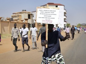 A demonstrator holds a placard during a rally protesting the United States unilateral arms embargo on the country, in the capital Juba, South Sudan Tuesday, Feb. 6, 2018.  Anti-Trump demonstrations in South Sudan's capital turned violent on Tuesday as people took to the streets to protest the U.S. president's new ban on the supply of weapons to the army or rebels.