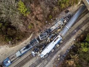 The wreckage of an Amtrak train, bottom, and a CSX freight train lie next to the tracks in Cayce, SC., on Sunday, Feb. 4, 2018. The trains collided in the early morning darkness Sunday, killing the Amtrak conductor and engineer, and injuring more than 100 passengers.