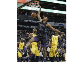 Charlotte Hornets' Dwight Howard, center, dunks in front of Indiana Pacers' Myles Turner, left, and Victor Oladipo, right, during the first half of an NBA basketball game in Charlotte, N.C., Friday, Feb. 2, 2018.