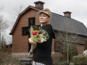 Jo Dockins, of Charlotte, N.C., carries flowers as she visits the Billy Graham Library in Charlotte, N.C., Wednesday, Feb. 21, 2018.  Spokesman Mark DeMoss says Billy Graham, who long suffered from cancer, pneumonia and other ailments, died at his home in North Carolina on Wednesday,  He was 99.