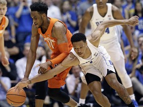Duke's Trevon Duval, front right, reaches for the ball with Syracuse's Oshae Brissett (11) during the first half of an NCAA college basketball game in Durham, N.C., Saturday, Feb. 24, 2018.