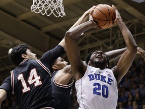 Duke's Marques Bolden (20) tries to shoot against Louisville's Anas Mahmoud (14) and Malik Williams during the first half of an NCAA college basketball game in Durham, N.C., Wednesday, Feb. 21, 2018.