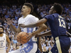 North Carolina's Cameron Johnson drives past Pittsburgh's Khameron Davis (13) during the first half of an NCAA college basketball game in Chapel Hill, N.C., Saturday, Feb. 3, 2018.