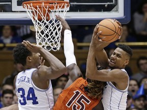 Duke's Wendell Carter Jr. (34) and Javin DeLaurier struggle with Virginia Tech's Chris Clarke (15) for a rebound during the first half of an NCAA college basketball game in Durham, N.C., Wednesday, Feb. 14, 2018.