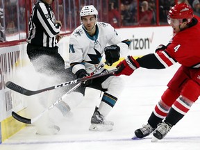 San Jose Sharks' Dylan DeMelo (74) dumps the puck over the stick of Carolina Hurricanes' Haydn Fleury (4) during the first period of an NHL hockey game, Sunday, Feb. 4, 2018, in Raleigh, N.C.