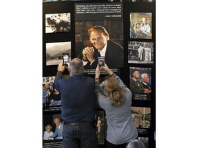 Chuck and Angela Riddle, of Morganton, N.C., photograph a memorial display in tribute to Rev. Billy Graham inside the chapel at the Billy Graham Training Center at the Cove on Wednesday, Feb. 21, 2018, in Asheville, N.C. The couple came to pay their respects and said Graham was a big influence in their lives.