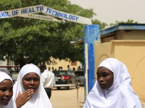 In this Thursday, June. 6, 2013 file photo, young women stand in front of a school in Maiduguri, Nigeria.