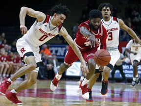 Indiana guard Robert Johnson (4) and Rutgers guard Geo Baker (0) battle for a loose ball in front of Rutgers guard Corey Sanders (3) during the first half of an NCAA college basketball game Monday, Feb. 5, 2018, in Piscataway, N.J.