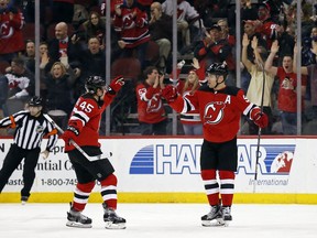 New Jersey Devils left wing Taylor Hall (9) is congratulated by Devils defenseman Sami Vatanen (45) after scoring a goal against the Minnesota Wild during the first period of an NHL hockey game, Thursday, Feb. 22, 2018, in Newark, N.J.