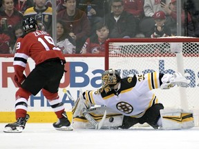 Boston Bruins goaltender Anton Khudobin, right, makes a save on a penalty shot by New Jersey Devils center Travis Zajac (19) during the first period of an NHL hockey game Sunday, Feb. 11, 2018, in Newark, N.J.