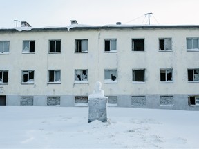 A monument to Lenin sits in front of an empty building in Nikel, Russia.