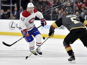 Montreal Canadiens center Byron Froese (42) and Vegas Golden Knights defenseman Deryk Engelland go after the puck during the first period of an NHL hockey game Saturday, Feb. 17, 2018, in Las Vegas.