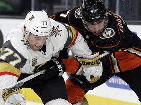 Vegas Golden Knights defenseman Brad Hunt, left, and Anaheim Ducks center Andrew Cogliano struggle for control of the puck during the first period of an NHL hockey game Monday, Feb. 19, 2018, in Las Vegas.