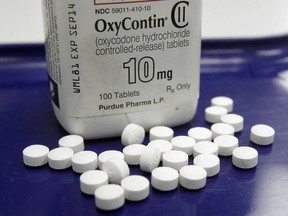 FILE - This Feb. 19, 2013 file photo shows OxyContin pills arranged for a photo at a pharmacy in Montpelier, Vt. The maker of the powerful painkiller  said it will stop marketing opioid drugs to doctors, a surprise reversal after lawsuits blaming the company for helping trigger the current drug abuse epidemic.  OxyContin has long been the world's top-selling opioid painkiller and generated billions in sales for privately-held Purdue.