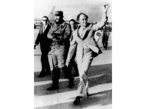 FILE - In this Jan. 1976 file photo, Canadian Prime Minister Pierre Trudeau, right, waves after arriving in Havana, accompanied by Cuban leader Fidel Castro. A story claiming that Fidel Castro was the father of Canadian Prime Minister Justin Trudeau is not true. The Canadian government denied it, Cuba has never claimed it and Trudeau's parents never visited Cuba until several years after Justin Trudeau was born.  (AP Photo, FILE)