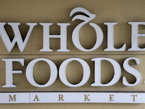 FILE - In this Aug. 28, 2017 file photo, a sign at a Whole Foods Market greets shoppers in Tampa, Fla. The online retailing giant plans to roll out two-hour delivery at the organic grocer this year to those who pay for Amazon's $99-a-year Prime membership. The move is the latest by Amazon to put its stamp on its recent purchase of Whole Foods.