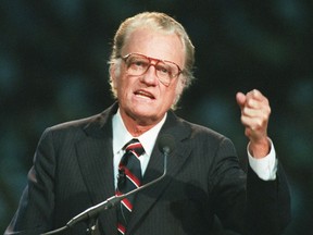 FILE - In this Oct 26, 1994 file photo, Evangelist Billy Graham begins his sermon in Atlanta's Georgia Dome.   Graham, who transformed American religious life through his preaching and activism, becoming a counselor to presidents and the most widely heard Christian evangelist in history, has died. Spokesman Mark DeMoss says Graham, who long suffered from cancer, pneumonia and other ailments, died at his home in North Carolina on Wednesday, Feb. 21, 2018. He was 99.