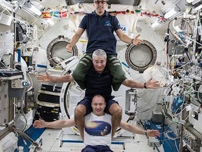 This image provided by NASA on Feb. 25, 2018, shows from bottom to top: Russia's Alexander Misurkin, NASA's Mark Vande Hei, middle, and NASA's Joe Acaba posing for a photograph at the International Space Station.  The three astronauts are headed back to Earth on Tuesday, Feb. 27,  following a nearly six-month mission at the International Space Station. Misurkin,  Vande Hei and Acaba moved into the orbiting lab in September. They are targeting a Kazakhstan touchdown for their Russian capsule.  (NASA via AP)