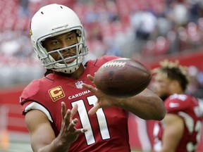 FILE - In this Dec. 10, 2017, file photo, Arizona Cardinals wide receiver Larry Fitzgerald warms up prior to an NFL football game against the Tennessee Titans in Glendale, Ariz. New Arizona coach Steve Wilks says Fitzgerald has told him he'll return for a 15th NFL season. Wilks made the comment Thursday, Feb. 15, 2018, in an interview on the "Doug &Wolf" sports talk radio show.