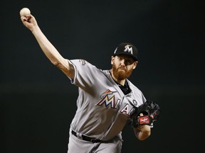FILE - In this Sunday, Sept. 24, 2017 file photo, Miami Marlins' Dan Straily warms up during the first inning of a baseball game against the Arizona Diamondbacks in Phoenix. Pitcher Dan Straily and Miami argued their arbitration case Thursday, Feb. 15, 2018. Straily, eligible for the first time, asked for a raise from $552,100 to $3.55 million from James Darby, Sylvia Skratek and Francis. The Marlins argued for $3,375,000.