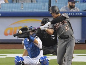 FILE - In this Sept. 4, 2017, file photo, then-Arizona Diamondbacks' Brandon Drury, right, hits a solo home run as Los Angeles Dodgers catcher Austin Barnes watches during the seventh inning of a baseball game, in Los Angeles. New Yankees third baseman Brandon Drury spent the offseason making a half-dozen trips from his home in Las Vegas to Los Angeles to be tutored by the same coaches who remade J.D. Martinez's swing into a home run force.