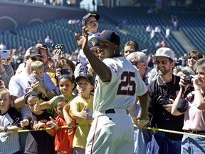 FILE - In this April 13, 2002, file photo, San Francisco Giants' Barry Bonds waves and poses for fans during the annual on-field photo day before the Giants' baseball game against the Milwaukee Brewers in San Francisco. Bonds will have his No. 25 jersey retired this August by the Giants when his former Pittsburgh Pirates are in town, the team announced Tuesday, Feb. 6, 2018.