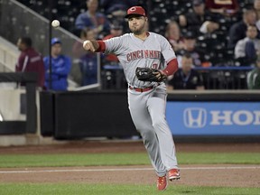 FILE - In this Sept. 7, 2017, file photo, Cincinnati Reds third baseman Eugenio Suarez throws out New York Mets' Kevin Plawecki during a baseball game in New York. The Reds won their salary arbitration case against Suarez, who gets a raise from $595,000 to $3.75 million rather than his request for $4.2 million.