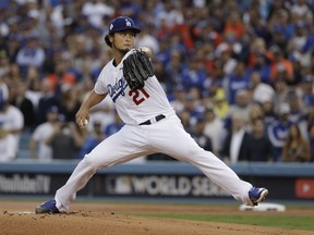 FILE - In this Nov. 1, 2017, file photo, Los Angeles Dodgers starting pitcher Yu Darvish throws during the first inning of Game 7 of baseball's World Series against the Houston Astros, in Los Angeles. Perhaps 100 free agents still seek contracts as the start of spring training workouts on Feb. 14 draws near, a group that includes J.D. Martinez, Eric Hosmer, Mike Moustakas, Jake Arrieta and Yu Darvish.