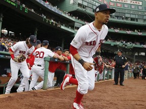 FILE - In this Oct. 9, 2017, file photo, Boston Red Sox's Mookie Betts runs onto the field for Game 4 of baseball's American League Division Series against the Houston Astros in Boston. Betts and the Red Sox have argued the first salary arbitration case of the year, with the All-Star outfielder asking for a raise from $950,000 to $10.5 million and the team offering $7.5 million. Arbitrators Dan Brent, Mark Burstein, Phillip LaPorte heard arguments Tuesday, Jan. 30, 2018, and a decision is expected Wednesday.