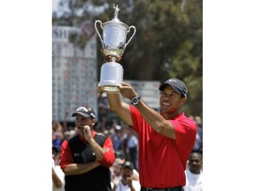 FILE - In this June 16, 2008, file photo, Tiger Woods holds up the championship trophy after winning the U.S. Open against Rocco Mediate, left, after a sudden death hole following an 18-hole playoff round at Torrey Pines Golf Course in San Diego. The U.S. Open is switching this year to a two-hole aggregate playoff.