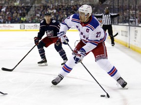 FILE - In this Oct. 13, 2017, file photo, New York Rangers defenseman Ryan McDonagh, right, looks to pass in front of Columbus Blue Jackets forward Matt Calvert during an NHL hockey game in Columbus, Ohio. The Tampa Bay Lightning have strengthened their NHL-leading team by acquiring Rangers' McDonagh.