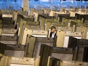 FILE- In this Oct. 14, 2016, file photo, a technician works to prepare voting machines to be used in the upcoming presidential election, in Philadelphia. Since last July, a bipartisan team at Harvard, including former U.S. Marine and Army cyberwarriors, national security eggheads and Google engineers, has been looking into how to safeguard the vote against interference. The group drafted its latest protect-the-vote election "playbooks" intended to prepare state and local officials for the worst.