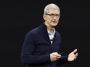 FILE- In this Sept. 12, 2017, file photo, Apple CEO Tim Cook, shows new Apple Watch Series 3 product at the Steve Jobs Theater on the new Apple campus in Cupertino, Calif. Cook is leaving shareholders in suspense about whether the iPhone maker will use its windfall from a tax cut on overseas profits for a big boost to its quarterly dividend.