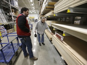 In this Friday, Feb. 23, 2018 photo Lowe's Assistant Store Manager Patrick Mulloney, of Marlborough, Mass., left, assists customer Karen Frank, of Framingham, Mass., right, at a Lowe's retail home improvement and appliance store, in Framingham. On Tuesday, Feb. 27, the Conference Board releases its February index on U.S. consumer confidence.