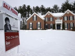 In this Monday, Jan. 8, 2018, photo a real estate sale pending sign hangs in front of an existing home, in Walpole, Mass. On Wednesday, Feb. 28, the National Association of Realtors releases its January report on pending home sales.