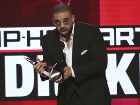 FILE - In this Nov. 20, 2016, file photo, Drake accepts the award for favorite artist - rap/hip-hop at the American Music Awards at the Microsoft Theater in Los Angeles. Drake made a surprise stop at a Florida homeless shelter for women and children, bringing a $50,000 check and toys and games for the kids. The Grammy-award winner stopped at Miami's Lotus Village on Tuesday, Feb. 6, 2018, to support families who moved into the nonprofit's new shelter one week ago. Drake passed out $150 Target gift cards for the female residents.