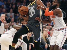 Golden State Warriors forward Kevin Durant (35) collides with New York Knicks guard Frank Ntilikina (11) and forward Tim Hardaway Jr. (3) during the first half of an NBA basketball game, Monday, Feb. 26, 2018, in New York.