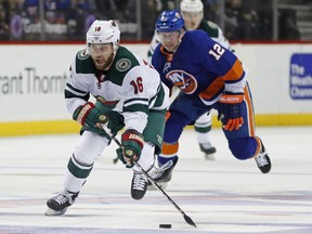 Minnesota Wild left wing Jason Zucker (16) skates with the puck as New York Islanders right wing Josh Bailey (12) pursues him during the third period of an NHL hockey game in New York, Monday, Feb. 19, 2018. The Wild defeated the Islanders 5-3.